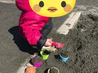 広々とした公園で芝生、砂場、遊具が...