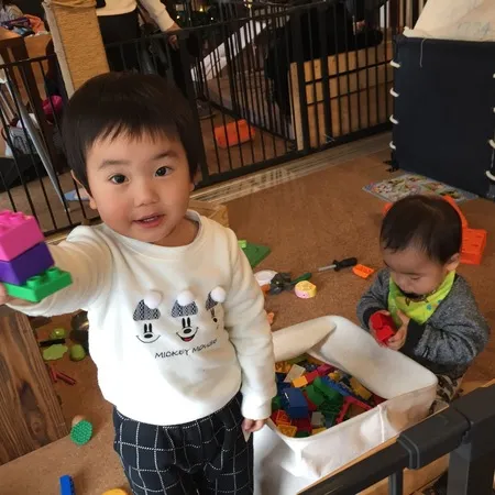 子どもが保育士さんのもと、おもちゃ...